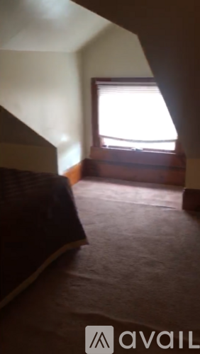 A room with a window and a bed.