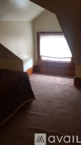 A room with a window and a bed.