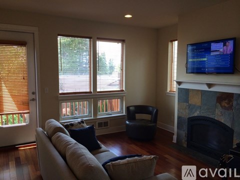 A living room with a couch, chair, and television.