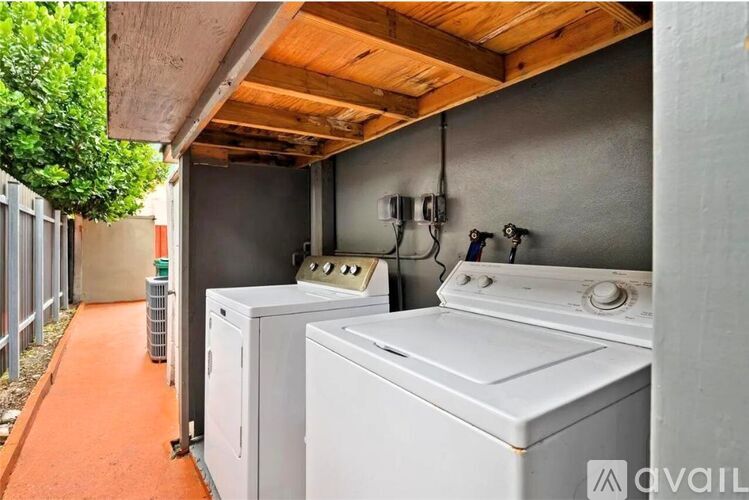 A washing machine and dryer are on a balcony.