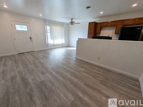 A spacious room with a ceiling fan and a television on the counter.