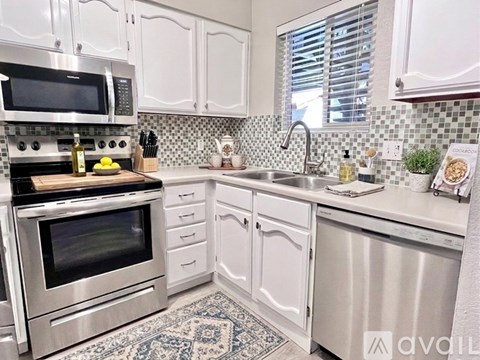 A kitchen with white cabinets and a stainless steel oven.