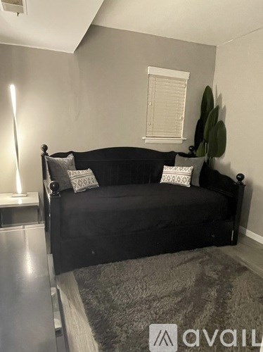A black sofa with pillows in a room.