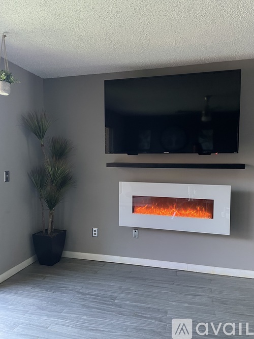 A modern living room with a fireplace and a potted plant.