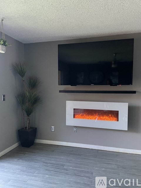 A modern living room with a fireplace and a potted plant.