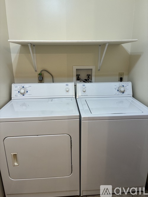 A white washing machine and dryer in a small laundry room.