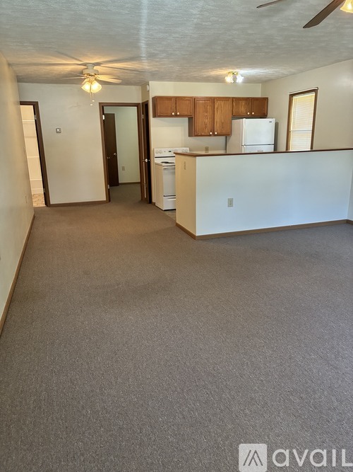 A kitchen area with a refrigerator, dishwasher, and a ceiling fan.