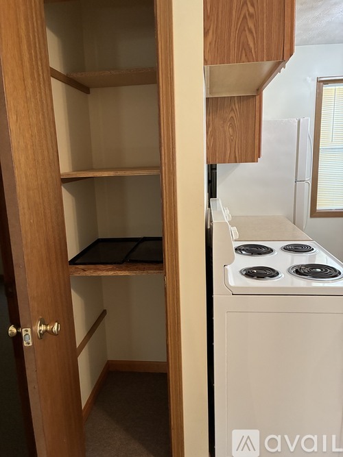 A small kitchen with a stove and an open door.
