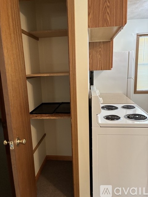 A small kitchen with a stove and an open door.