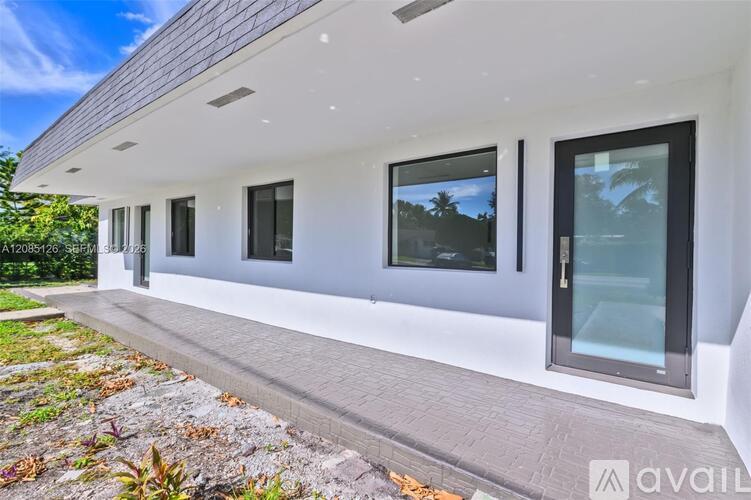 A modern house with a white exterior and large windows.