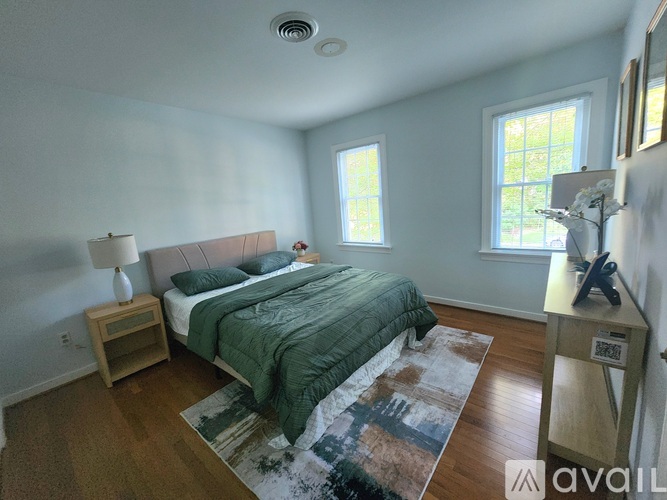 A bedroom with a bed, nightstand, and window.