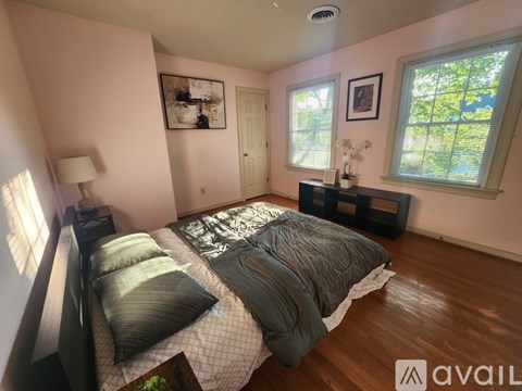 A bedroom with a large bed and a window with a view of trees.