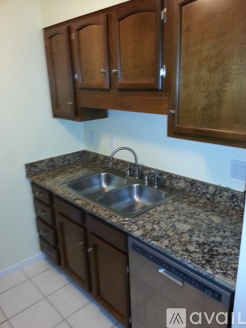 A kitchen with granite countertops and wooden cabinets.