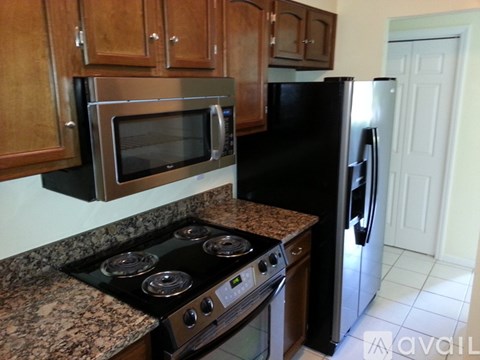 A kitchen with a black refrigerator and stove.
