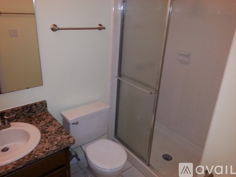 A bathroom with a toilet, sink, and shower.