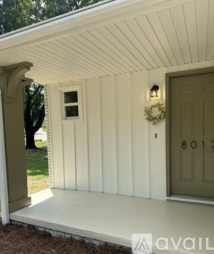 A white house with a door numbered 8017.