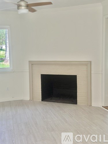 A room with a fireplace and a ceiling fan.