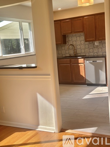 A kitchen with brown cabinets and a white fridge.