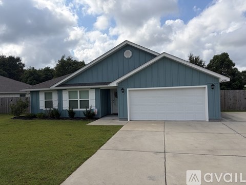 A blue house with a white garage door and a driveway.