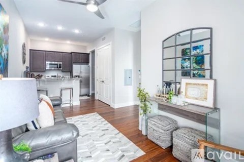 A living room with a grey couch and a glass table.