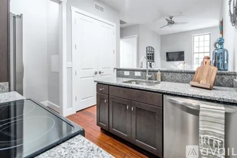 A modern kitchen with a stainless steel dishwasher and a black granite countertop.