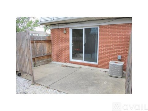 A red brick house with a sliding glass door and a wooden fence.