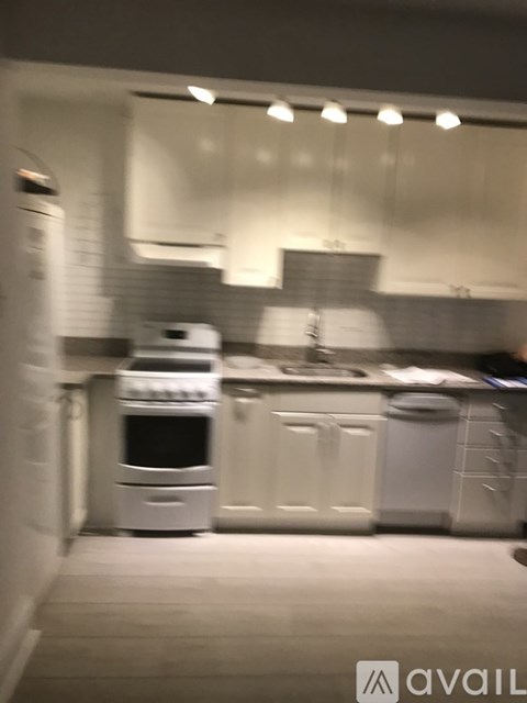 A kitchen with white appliances and cabinets.
