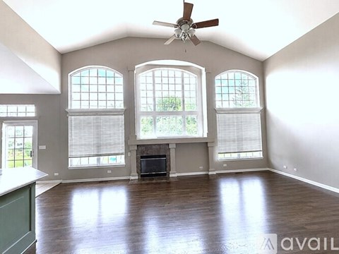 A spacious room with a fireplace and large windows.