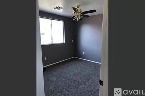 A room with a ceiling fan and a window.
