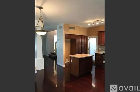 A kitchen area with brown cabinets and a wooden island.