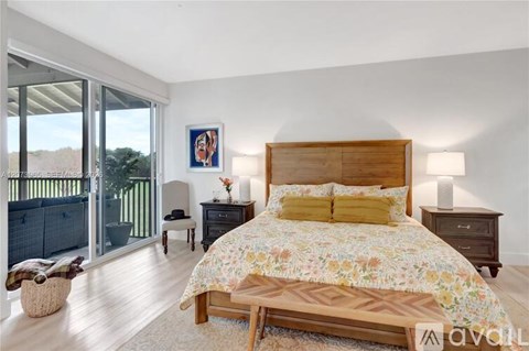 A bedroom with a large bed and a balcony.