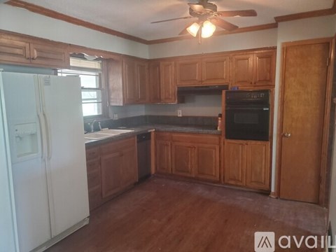 A kitchen with wooden cabinets and a white fridge.