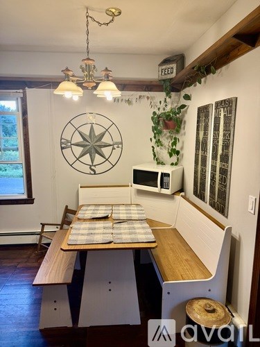 A kitchen with a compass on the wall and a table with a plant on top.