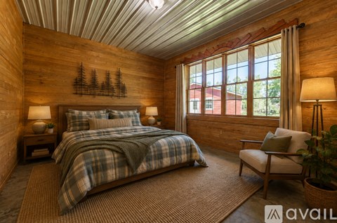 A bedroom with a bed, chair, and wooden walls.