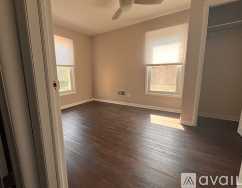 A room with wooden flooring and a ceiling fan.