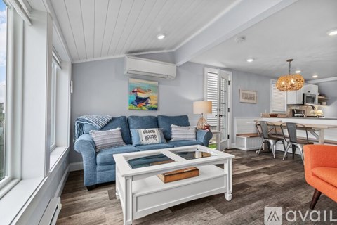 A living room with a blue couch and a white coffee table.