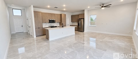 A spacious kitchen with a white island and a refrigerator.