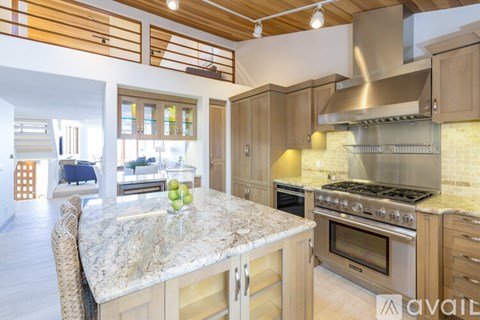 A kitchen with a granite countertop and wooden cabinets.