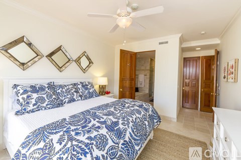 A bedroom with a large bed and a ceiling fan.
