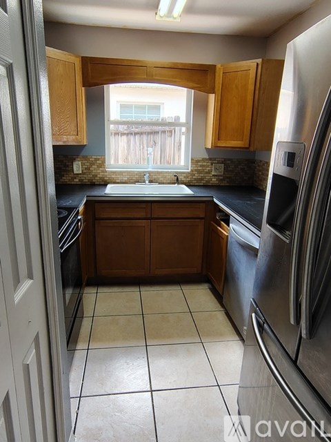 A kitchen with wooden cabinets and a black counter top.