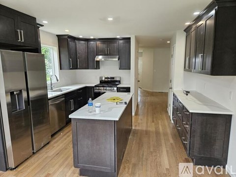 A kitchen with wooden floors and stainless steel appliances.