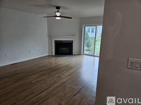 A room with a fireplace and a ceiling fan.