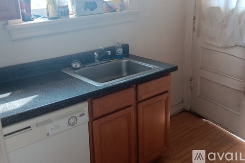A kitchen with a black countertop and white appliances.