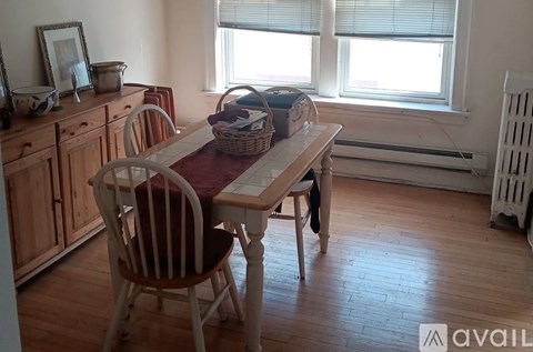 A dining room with a wooden table and chairs.