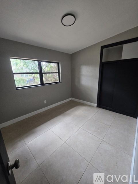 A room with a window and tiled floor.