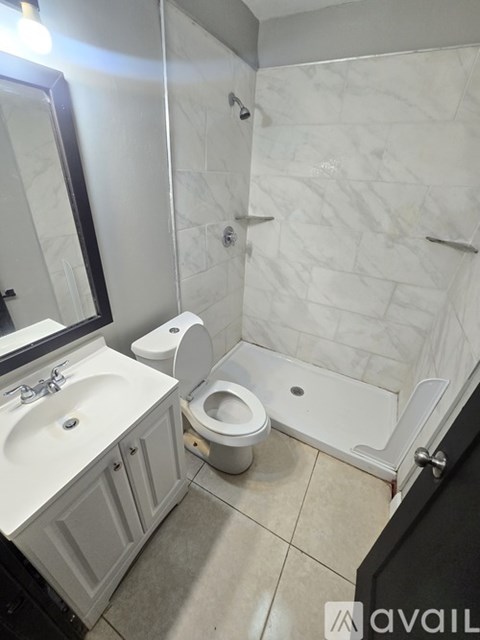 A bathroom with a toilet, sink, and shower.