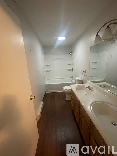 A bathroom with a toilet, sink, and mirror.