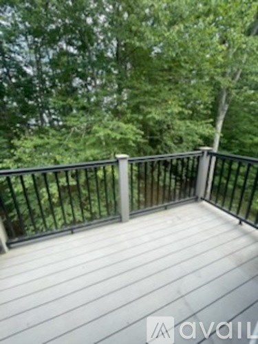 A deck with a railing and trees in the background.