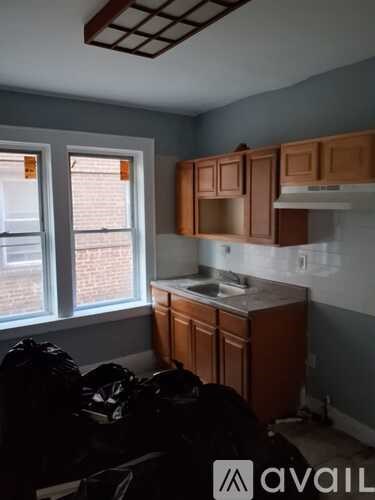 A kitchen with brown cabinets and a window.