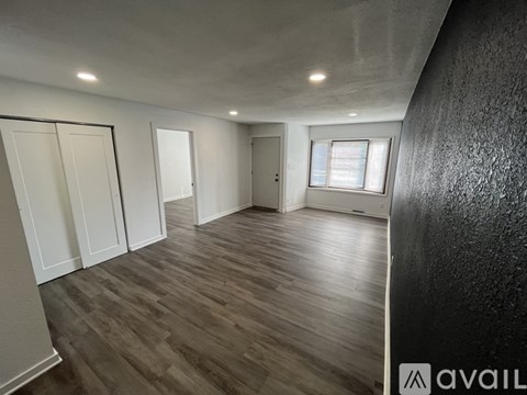 A room with wooden flooring and white walls.